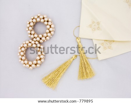 Two gold beaded napkin holders and a table runner on a white background
