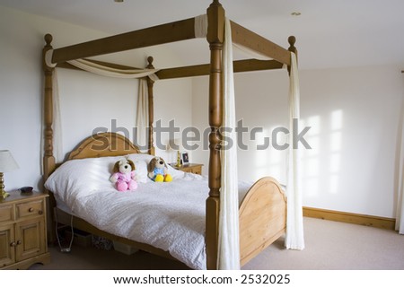 A four poster bed in a white bedroom