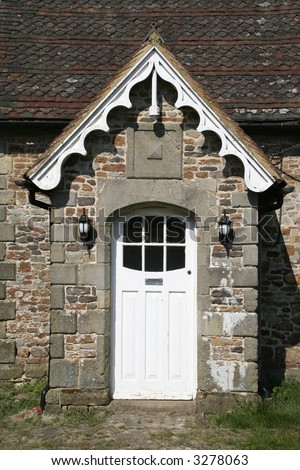 A white wooden front door in a stone porch