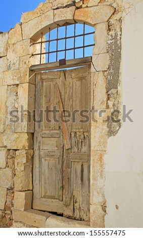 Old doors at ruined house at village Panormo, Crete - Greece