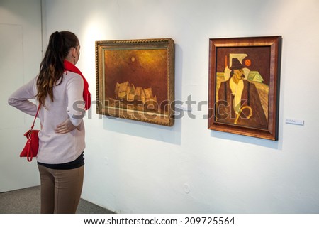 RUZOMBEROK, SLOVAKIA - JULY 22: Girl looking at Bazovsky\'s painting in gallery of Ludovit Fulla on July 22, 2014 in Ruzomberok