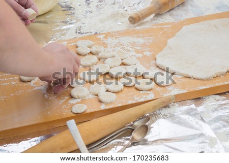 round billets of dough on the board and rolling pin