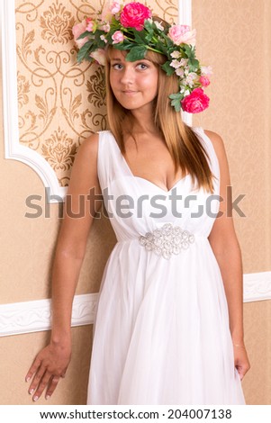 portrait girl like spring with wreath on his head on background of beige classic wall
