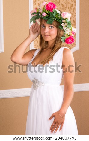 portrait young woman with wreath on his head on background of beige wall