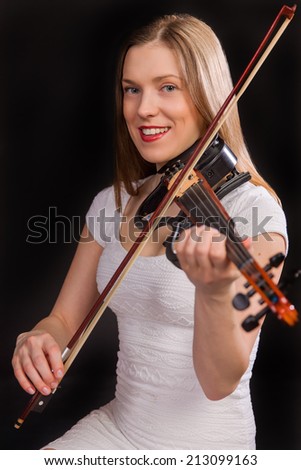 beautiful smiling girl in white dress playing on electro violin