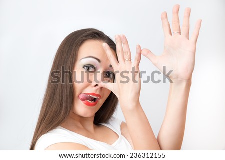 Portrait of grimacing girl with tongue sticking out on  white background