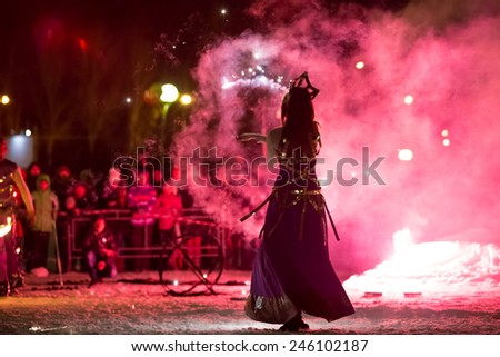 Perm, Russia - January 17, 2015. Woman in costume of queen in red smoke