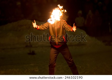 Perm, Russia - January 17, 2015. Fiery poi on circuit covered his face man