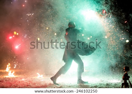 Perm, Russia - January 17, 2015. Man with two torches surrounded by red and blue sparks fireworks