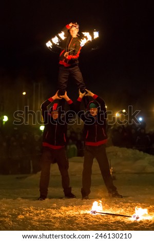 Perm, Russia - January 17, 2015. Two men hold the third with  fiery stick