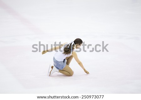 Perm, Russia - January 31, 2015. Figure skating competitions among fans. Girl in a denim skirt and white shirt kneel on ice skates