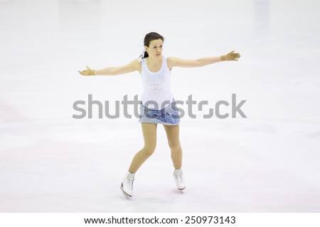 Perm, Russia - January 31, 2015. Figure skating competitions among fans. Girl in a denim skirt and white shirt dancing on ice skates on  competitions