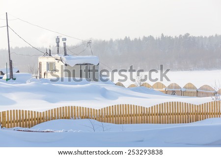 House behind the fence in winter