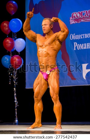 Perm, Russia - April 19, 2015.Cup Perm Krai  on bodybuilding and fitness bikini. Muscular man in pink  briefs showing double biceps