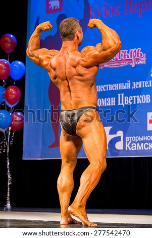 Perm, Russia - April 19, 2015.Cup Perm Krai  on bodybuilding and fitness bikini. bodybuilder in black briefs showing double biceps from behind