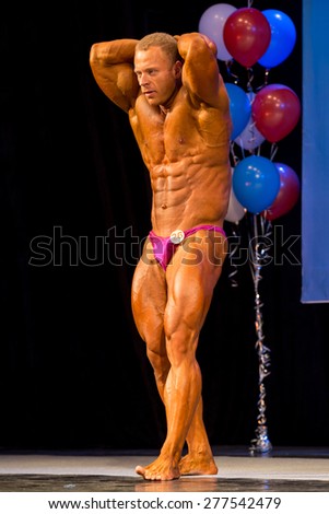 Perm, Russia - April 19, 2015.Cup Perm Krai  on bodybuilding and fitness bikini. bodybuilder in pink briefs show muscles  thighs and press