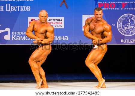 Perm, Russia - April 19, 2015.Cup Perm Krai  on bodybuilding and fitness bikini. Two bodybuilder show biceps