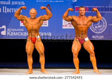 Perm, Russia - April 19, 2015.Cup Perm Krai  on bodybuilding and fitness bikini.  Two bodybuilder in red briefs show  double biceps