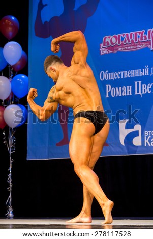 Perm, Russia - April 19, 2015.Cup Perm Krai  on bodybuilding and fitness bikini. Bodybuilder in black briefs  showing double biceps during performances