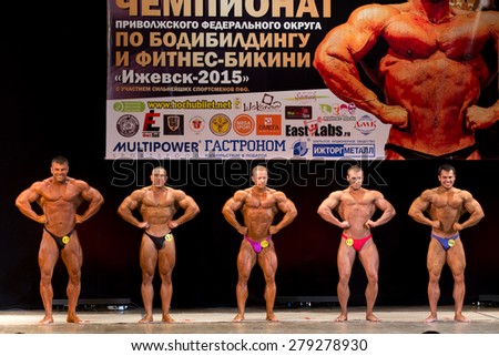 Izhevsk, Russia - April 18, 2015. Open championship of the Volga Federal District of bodybuilding and fitness bikini. Large bodybuilders are on the scene to compare