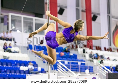 Perm, Russia - April 25, 2015. Championship Perm region at pole sport and dance. The girl in the purple costume making element open knees
