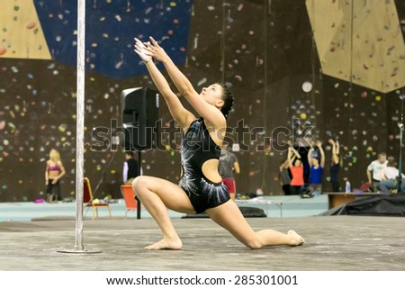 Perm, Russia - April 25, 2015. Championship Perm region at pole sport and dance.  The brunette in a black bathing suit stands on competition