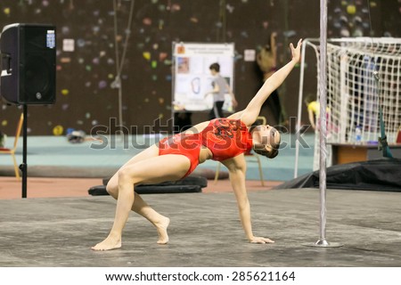 Perm, Russia - April 25, 2015. Championship Perm region at pole sport and dance. girl in an orange swimsuit makes the item bridge on one hand