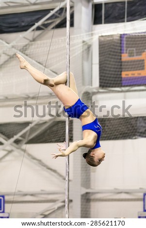 Perm, Russia - April 25, 2015. Championship Perm region at pole sport and dance. young girl in a blue swimsuit making element Jasmine