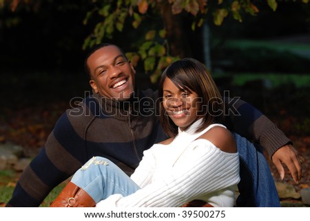 African-American Couple smiling sitting in the grass