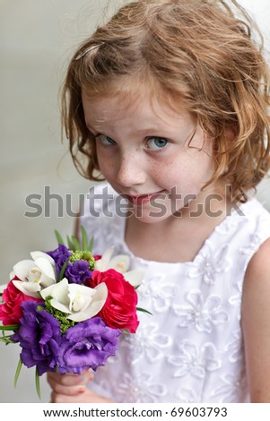 Cute flower girl holding a small bouquet of flowers
