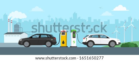 Gasoline car refuel and electric car charge at the station, refinery and wint turbines in the background, automotive technology and green energy concept