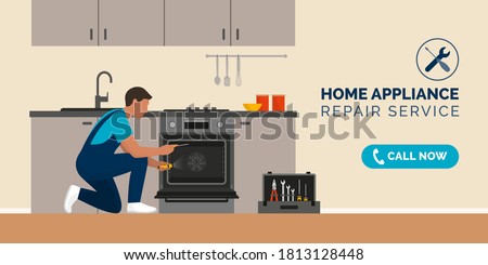 Expert repairman fixing a broken oven in a kitchen, home appliance repair service concept