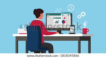 Efficient businesswoman working online, she is sitting at desk and checking business charts on the computer, remote work concept