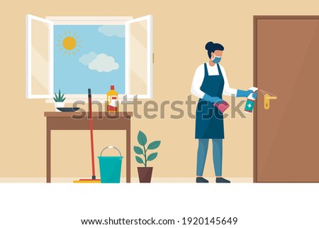 Woman disinfecting surfaces in her house, she is wearing gloves and face mask: keep your home safe and clean during the coronavirus pandemic Imagine de stoc © 