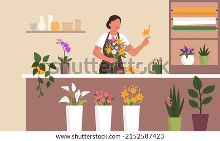 Professional florist working in her flower shop she is preparing a beautiful gift bouquet