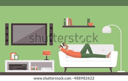 Man relaxing on the sofa in the living room, he is listening to music and resting