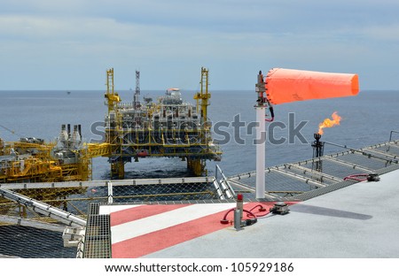 The wind sock is set on the oil rig to showing wind direction for  helicopter landing .