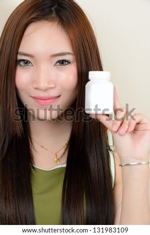 portrait of beautiful  smiling healthy asian woman is holding supplementary food container