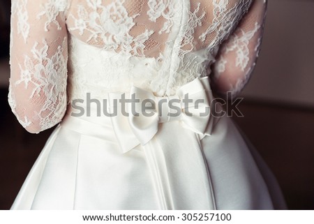 White wedding dress bride with a beautiful bow and lace on the back. Wedding accessories. Female jewelry for girls. Details for marriage and for a married couple