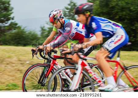 Pyatigorsk , Russia - September 4, 2014: Three cyclist in bright sports uniform riding along a forest road on sports bikes.
