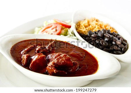 A plate of chili colorado with rice and beans.