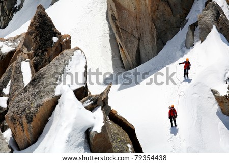 Team of two alpinists climbing a mountain