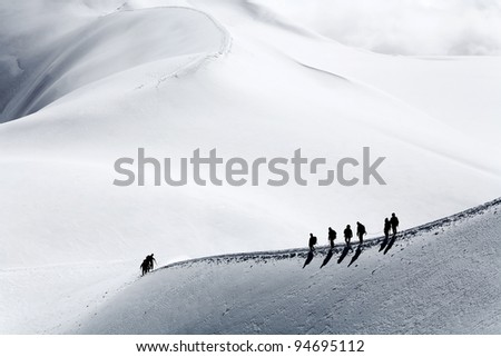 Team of alpinists climbing a mountain