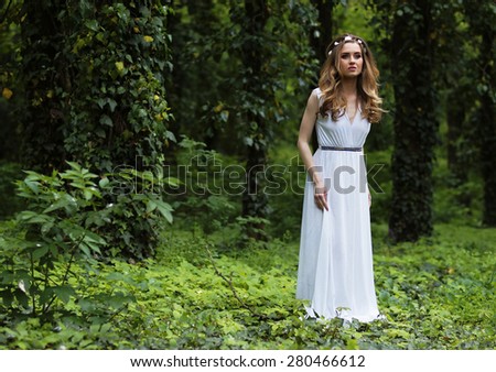 Art fashion portrait of young woman walking in the woods