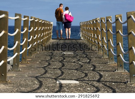 Young couple walking on a ocean pier