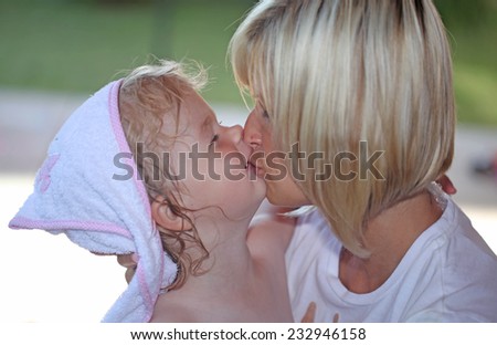 Young mother kissing her daughter