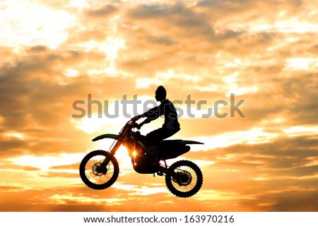 Motocross  jump on  sunset  background