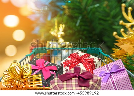 christmas gifts and presents in shopping trolley with christmas decorations and blurred lights on christmas tree - Light Up Presents Christmas Decorations christmas gifts and presents in shopping trolley with christmas decorations and blurred lights on christmas tree - Light Up Presents Christmas Decorations