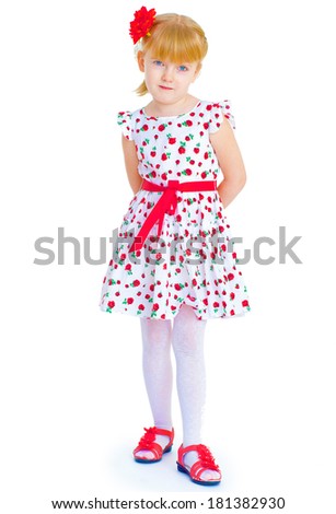 Charming little girl standing leg thrust forward and have fun looking at the camera.Isolated on white background.