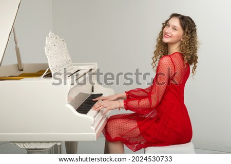 Similar – Image, Stock Photo Smiling woman playing piano in living room